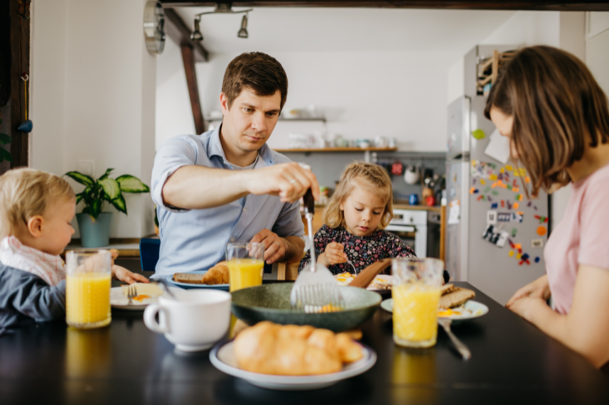 Familie sitzt zusammen beim Frühstück