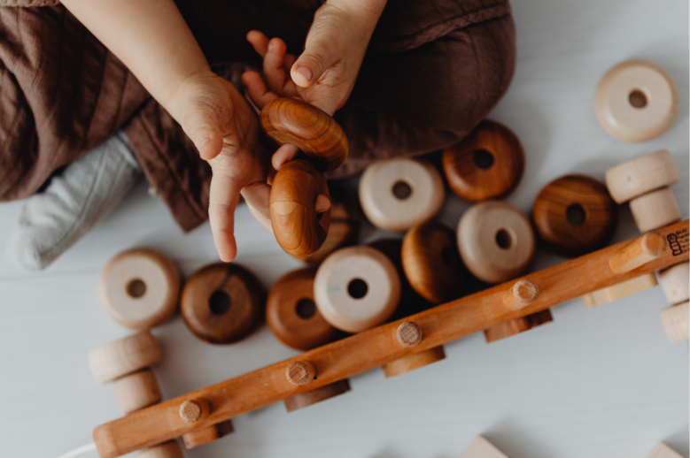 Kleinkind spielt mit Holzspielzeug